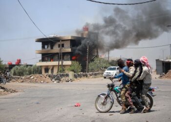 PEJUANG puak merentasi pekan Walga ketika pertempuran makin reda berhampiran bandar Sweida di selatan Syria.-AFP