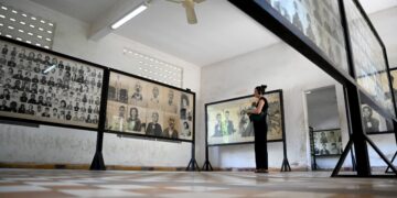 PELANCONG melihat potret mangsa-mangsa kekejaman rejim Khmer Rouge di Phnom Penh, Kemboja. – AFP