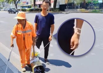SEORANG tukang sapu wanita membersihkan kawasan jalan sambil membawa bersama anak lelakinya yang kurang upaya berhampiran tarikan pelancong terkenal di Xi'an, wilayah Shaanxi.-AGENSI
