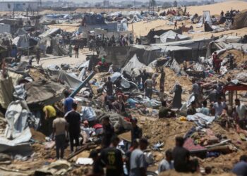 PENDUDUK Palestin memeriksa kemusnahan di kem perlindungan sementara di Khan Younis, susulan pencerobohan kereta kebal Israel pada 10 Julai lalu.- AFP