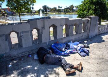 DUA lelaki gelandangan tidur di pejalan kaki di Taman MacArthur di Los Angeles, California. – AFP