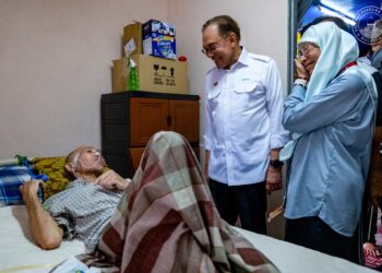 ANWAR beramah mesra dengan Mohamad Ali Abdul Malek ketika menziarahi keluarga asnaf itu di Kampung Baru Sirusa, Port Dickson, Negeri Sembilan. - FACEBOOK ANWAR IBRAHIM