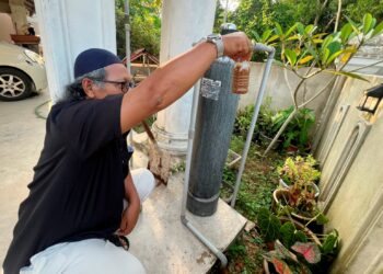 ASMADI Mohammad menunjukkan kualiti air tapisan bumi di Kampung Pasir Sotong, Pasir Puteh, Kelantan. – UTUSAN/TOREK SULONG