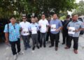 MOHD. Fitri Asmuni (tiga dari kiri) menunjukkan laporan polis yang dibuat di Ibu Pejabat Polis Daerah (IPD) Ipoh hari ini. - UTUSAN