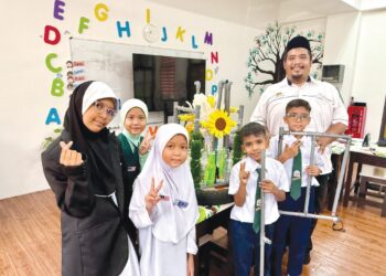 IZZAT Fadhli Hamdan dan murid-muridnya bersama alat bantuan mengajar SteP yang dihasillkannya ketika ditemui 
di SK Nilai Impian, Nilai, Seremban. – UTUSAN/NOR SHAFIQAH MOHD GHAZALI