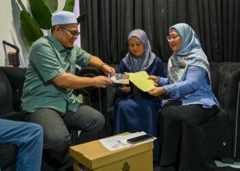 HISHAMUDDIN Abdul Karim bersama Suhara Mustaffa (kanan) menyampaikan faedah Perkeso kepada Rusmailaili Samsuri (tengah) di Taman Batin Perdana, Kuala Nerus, Terengganu. - UTUSAN/PUQTRA HAIRRY