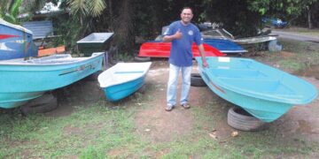 Faizal Amirul Salehodin menunjukkan isyarat bagus di samping beberapa bot gentian kaca yang telah disiapkan di Kampung Gelam, Tanjong Kling, Melaka. – UTUSAN/AMRAN MULUP