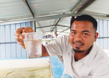 MUHAMMAD Arif Mohd. Yasin menunjukkan benih ikan keli yang berusia tiga hari di Kampung Gadong, Rembau, Negeri Sembilan. 
– UTUSAN/NOR AINNA HAMZAH