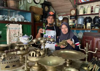 RASHIDI Baharudin dan isterinya, Siti Farhana menunjukkan koleksi barang antik yang dikumpul mereka ketika ditemui di kedai miliknya yang terletak di pekan Johol, Kuala Pilah.-UTUSAN/ NOR SHAFIQAH MOHD GHAZALI