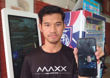 MOHAMAD Hariz Akmal Mohd. Jais menunjukkan gambar swafoto yang diambil ibunya di dalam helikopter beberapa minit sebelum ia berlepas dari Balai Polis Tanjung Kupang, kelmarin.