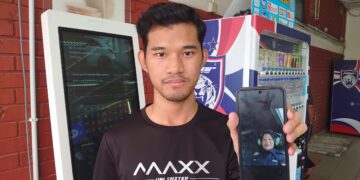 MOHAMAD Hariz Akmal Mohd. Jais menunjukkan gambar swafoto yang diambil ibunya di dalam helikopter beberapa minit sebelum ia berlepas dari Balai Polis Tanjung Kupang, kelmarin.
