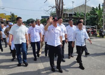 NGA Kor Ming (depan) melambai tangan kepada orang ramai sebaik tiba di lokasi Program Sentuhan Kasih 3.0 di Kampung Penambang, Kota Bharu, Kelantan hari ini. - UTUSAN/MUSTAQIM MOHAMED