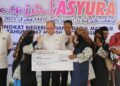 WAN ROSDY Wan Ismail (tengah) menyampaikan hadiah replika cek bernilai RM3,000 kepada juara Karnival Asyura, Masjid Tengku Abdullah, Jerantut di Temerloh, Pahang. - FOTO/SALEHUDIN MAT RASAD