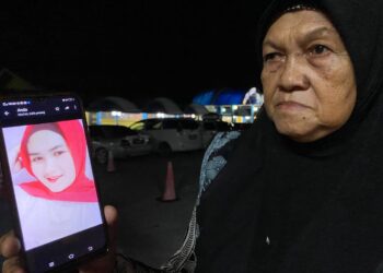 ZAWIYAH Sulong menunjukkan gambar cucunya yang maut dengan kesan tembakan pada bahagian perut sebelah kiri dalam kejadian di Kampung Repek, Pasir Mas, Kelantan tiga tahun lalu.