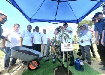 WAN ROSDY Wan Ismail (tengah) menanam pokok Durian Duri Hitam pada Program Moh Kendurian 3.0 Ladang Kampung Mahkota Pertubuhan Peladang Negeri Pahang (PASFA) di Kuantan, Pahang. - FOTO/SHAIKH AHMAD RAZIF