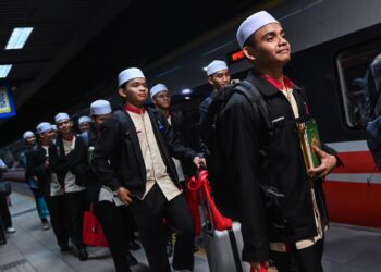 PARA peserta program Al-Quran Di Mana-Mana 2.0 ketika menuju ke platform ETS ke Hat Yai pada majlis pelepasan yang diadakan di KL Sentral di sini, hari ini. - UTUSAN/SYAKIR RADIN