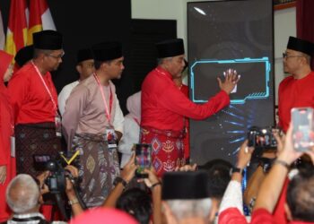 AHMAD ZAHID Hamidi meletakkan tapak tangan ke atas skrin sebagai gimik perasmian Mesyuarat Perwakilan UMNO Bahagian Sri Gading di Dewan Orang Ramai Parit Raja, Batu Pahat.