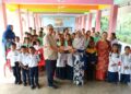 ABD. Manaf Mat (depan, kiri) menyampaikan sumbangan alat tulis kepada Nor Fazilah Abdullah sambil disaksikan sebahagian murid di Sekolah Kebangsaan Sungai Kiol, Jerantut, Pahang baru-baru ini. 
– Utusan/HARIS FADILAH AHMAD