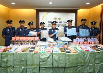 MOHD. Nadzri Ariffin (tengah) menunjukkan barang yang dirampas dalam serbuan pada sidang akhbar di Ipoh hari ini. - UTUSAN/MUHAMAD NAZREEN SYAH MUSTHAFA