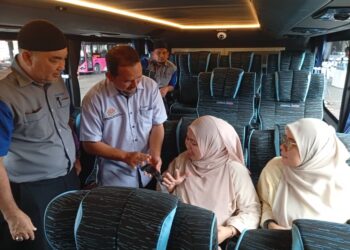 MOHAMAD Fakhri Manosr (dua kiri) menunjukkan tali pinggang keledar yang perlu dipakai penumpang bas selepas Perasmian Bas Darul Iman Express di Terminal Bas Kuala Terengganu. UTUSAN/ ERMA YUSNIDA JUSOH