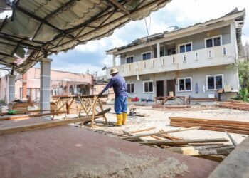 Pekerja kontraktor giat melakukan kerja pembaikan rumah di Kampung Kuala Sungai Baru yang terjejas akibat kebakaran saluran paip gas di Putra Heights, semalam. – UTUSAN/AFIQ RAZALI