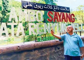 ABU Bakar Yazid terpaksa 'mencari' rangkaian telefon di kawasan air terjun Lata Renyuk, Jeli, Kelantan. – UTUSAN/YATIMIN ABDULLAH