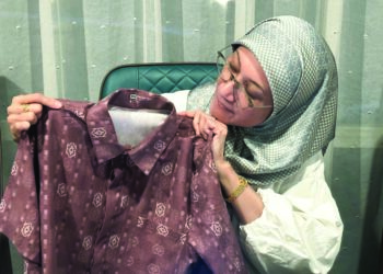 SHARMILA Mohamed Salleh menunjukkan baju bercorak etnik Sabah yang dihasilkan oleh Anne Antah.