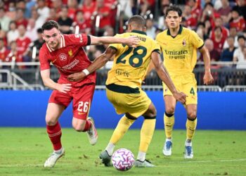 Pemain AC Milan, Malick Thiaw (tengah) cuba mengasak pemain Liverpool, Andy Robertson (kiri) dalam aksi persahabatan di Stadium Kai Tak, Hong Kong. kelmarin. - AFP