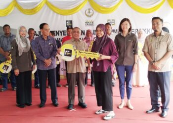 SAARANI Mohamad (tiga dari kiri) menyerahkan replika kunci rumah kepada pembeli sebagai simbolik majlis penyerahan kunci kepada pembeli unit Rumah Perakku di Taman Perakku Batu 14 Lekir, Manjung hari ini. - UTUSAN/FADZIL ZAINOL