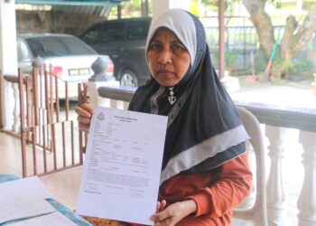 RAHANNAH Mohd. menunjukkan salinan laporan polis berkaitan kegiatan scammer yang menyebabkan kerugian RM34,000 ketika ditemui di Felda Jengka 2, Maran, Pahang.