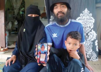 YUSMADI Yusof dan Sharifah Fatimah Mardiyyah Syed Zahiddin Idid menunjukkan gambar Yusrina Shafira di Kampung Kuala Mai, Kuala Krau di Temerloh, Pahang. – UTUSAN/SALEHUDIN MAT RASAD