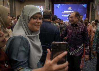 ANWAR Ibrahim beramah mesra dengan kakitangan Kementerian Kewangan pada Perhimpunan Bulanan Perdana Menteri bersama warga kementerian itu di Putrajaya, semalam. – UTUSAN/FAIZ ALIF ZUBIR