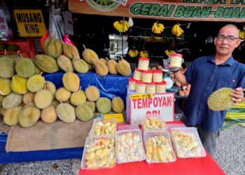 ZULKIFLI Fauzi menunjukkan tempoyak dan durian yang dijual di gerainya di Kampung Banjar, Teluk Intan, Perak. – UTUSAN/AIN SAFRE BIDIN