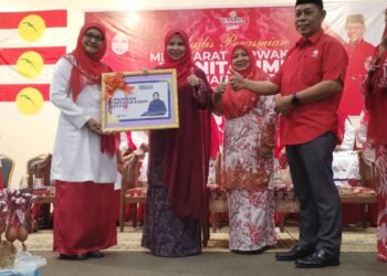 NRRLIZA Abdul Rahim (dua dari kiri) menyerahkan replika Perbadanan Tabung Pendidikan Tinggi Nasional (PTPTN)  pada Mesyuarat Perwakilan Wanita UMNO Bahagian Besut di Gong Kemuntong, Besut, Terengganu. - UTUSAN / WAN ZURATIKAH IFFAH WAN ZULKIFLI