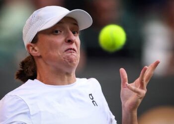 IGA Swiatek mengintai bola ketika menentang pemain Denmark, Clara Tauson aksi pusingan keempat pada hari kelapan Kejohanan Tenis Wimbledon 2025 di The All England Lawn Tennis and Croquet Club, semalam. - AFP