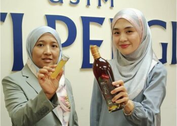 DR. Nur Ayman Abdul Hayei (kiri) dan Dr. Misya Humaira menunjukkan produk ubat kumur klinikal berasaskan madu kelulut yang dihasilkan.