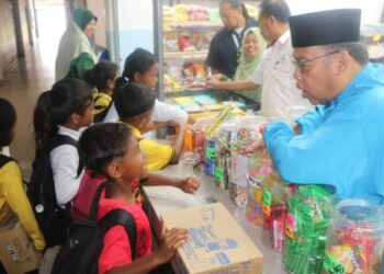 ABDUL Fattah Abdullah menyantuni pelajar selepas merasmikan Koperasi SMK RPS Betau Berhad  baru-baru ini.