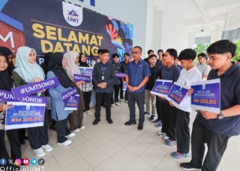 MOHD. Izani Mohd Zain (tengah) menyantuni penerima bantuan Bingkas Kasih UMT dalam Majlis Jalinan Mesra Pelajar di Kuala Nerus baru-baru ini.
