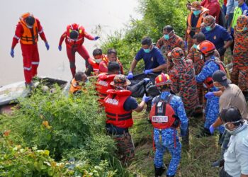 ANGGOTA penyelamat bertungkus lumus mengeluarkan mayat enam mangsa lemas dari dalam kereta yang dinaiki mereka yang tenggelam di dalam Sungai Korok di Jitra, Kedah, semalam.-UTUSAN/ SHAHIR NOORDIN