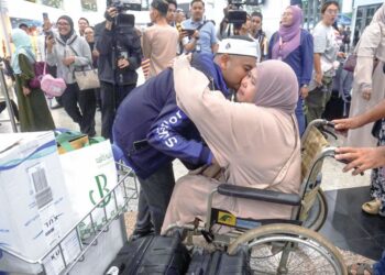 Muhammad Danial Mohd. Sulaiman memeluk ibunya, Hafizah Amdan sebaik sahaja tiba di Lapangan Terbang Antarabangsa Kuala Lumpur (KLIA), semalam, selepas terkandas di Jeddah, Arab Saudi. – UTUSAN/FAISOL MUSTAFA