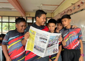 Muhammad Fawwaz (dua dari kiri) dan Ng Genly (tengah) teruja membaca berita mengenai sekolah mereka yang tersiar dalam sisipan Utusan Pelajar, baru-baru ini.