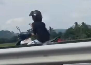 TANGKAP layar video tular memaparkan seorang wanita menunggang motosikal secara melawan arus sambil menggunakan telefon bimbit di di Kilometer 38 Lebuhraya Utara-Selatan arah selatan, berhampiran Plaza Tol Hutan Kampung di Alor Setar.