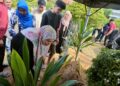 FILDAANIS Mat (depan) menyiram air mawar di pusara suaminya di Tanah Perkuburan Masjid Ridwaniah Sungai Batu, Teluk Kumbar, Pulau Pinang.