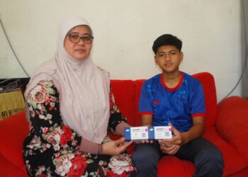 SHALENA Ismail bersama Amier Syahmi KD Azlan menunjukkan ubat sunitinib ketika ditemui di Kampung Solok Kubang Badak Sungai Siput, Lubok China, Melaka. – UTUSAN/AMRAN MULUP