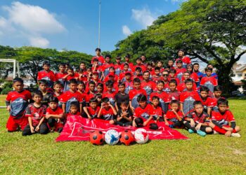 ADLI Hafdzan (Tengah) bersama barisan jurulatih dan pemain-pemain bola sepak kanak-kanak Kelab Lestari Vipers pada majlis penyerahan tajaan jersi di Seri Kembangan, Selangor.