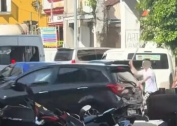 TANGKAP layar satu rakaman video yang tular di media sosial menunjukkan seorang lelaki (berbaju putih) memegang besi dan cuba merosakkan kereta milik pengguna jalan raya lain di Jalan Lebuh Pantai, George Town, Pulau Pinang.-GAMBAR/FACEBOOK