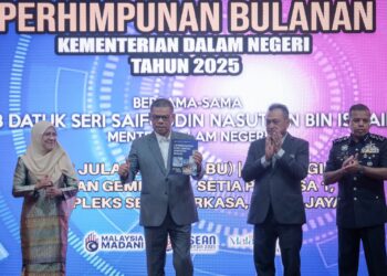 SAIFUDDIN Nasution Ismail menunjukkan buku Laporan Indeks Keselamatan Semapadan Negara (IKSN) pada Majlis Perhimpunan Bulanan KDN di Putrajaya. - UTUSAN/FAIZ ALIF ZUBIR