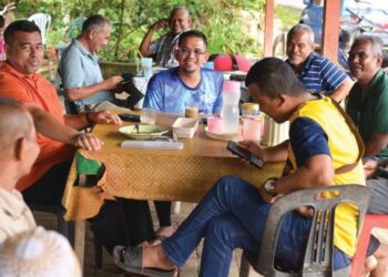 MOHD. Azmawi Fikri Abdul Ghani (tengah) tekun mendengar masalah yang diutarakan oleh penduduk semasa menyantuni mereka di salah sebuah kedai kopi di DUN Nenggiri, Gua Musang, Kelantan.