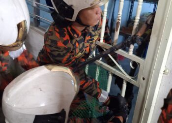 BEBERAPA anggota bomba sedang membuka pintu sebuah kereta yang terkunci di Taman Ara Mutiara, Tasek Gelugor, Pulau Pinang.-GAMBAR/JBPM PULAU PINANG