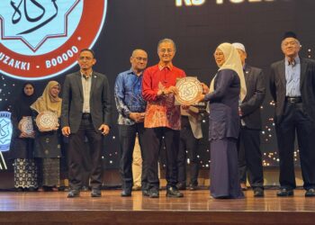 MOHAMAD Abdul Hamid (tengah) ketika menyampaikan plak Logo Rakan Muzakki Zakat MAINPP kepada usahawan di sebuah hotel di Seberang Jaya, Pulau Pinang.